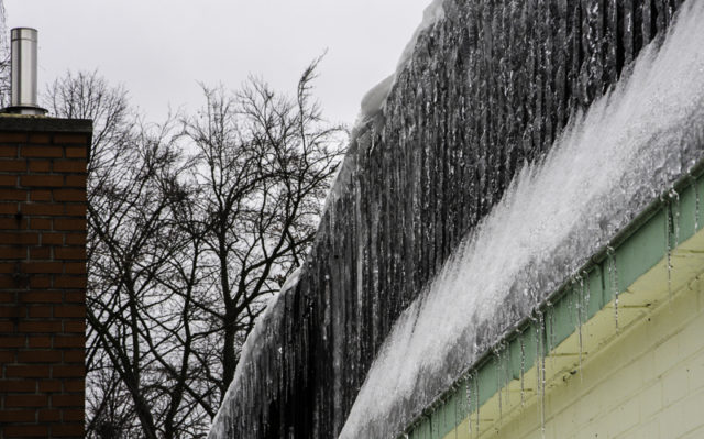 Verstopfte Dachrinne mit Eiszapfen