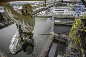 Industriekletterer streicht Konstruktion einer Plattform