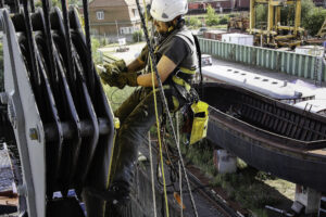 Kletterarbeiter entfernt Rost