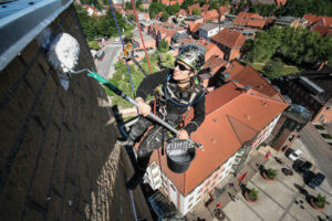 Höhenarbeiter beschichtet eine Fassade