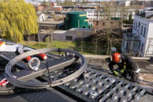 Industriekletterer montiert ein Rückhaltesystem auf ein Dach