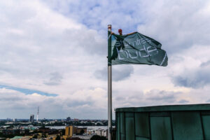 Kletterarbeiter repariert Fahnenmast